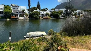 A lakeside residential area with houses, boats, and a mountain backdrop. - Heaven  (Cape Town)