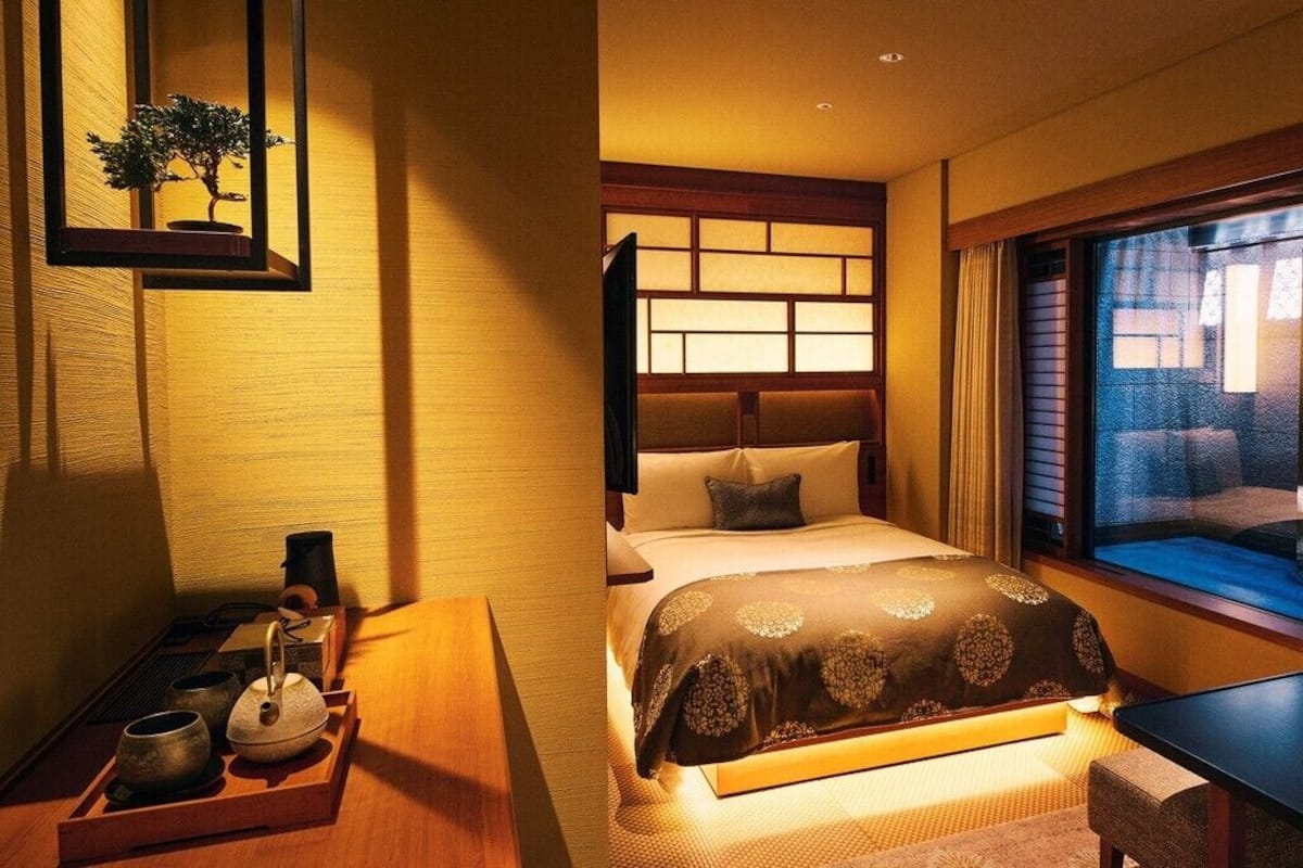 Ein Hotelzimmer mit Bett, Nachttisch und Fenster mit Blick.
