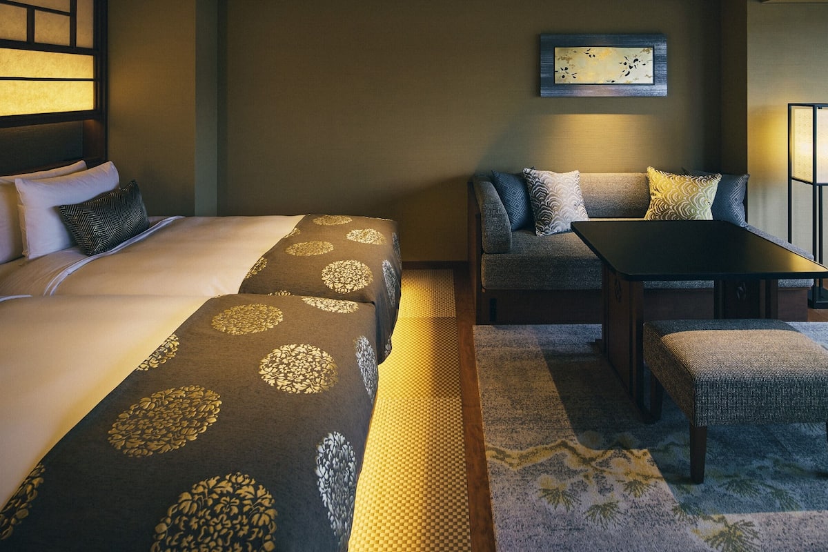 Ein Hotelzimmer mit Bett, Sofa, Tisch und Stuhl.
