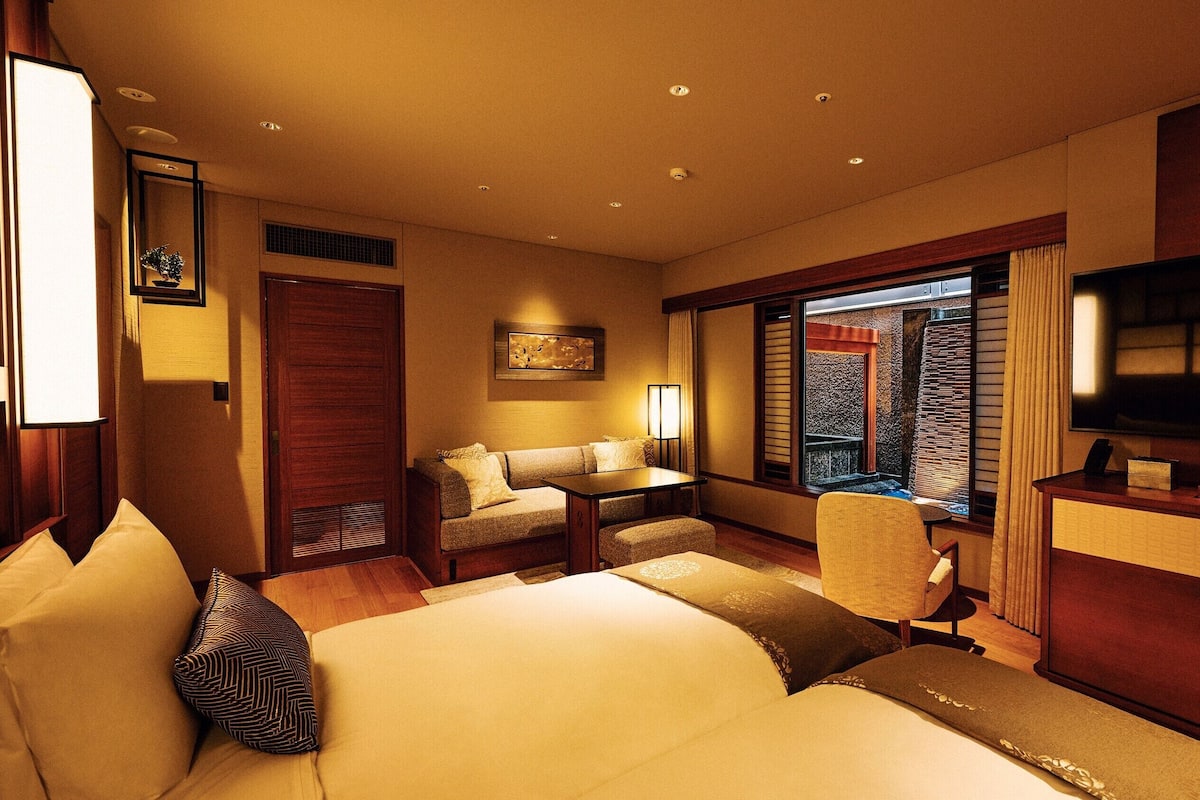 Ein Hotelzimmer mit Bett, Schreibtisch, Stuhl, Fernseher und Fenster mit Blick.