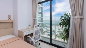 Un dormitorio moderno con un ventanal grande, un escritorio, una silla y una cama.