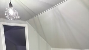 Ein kleiner, moderner Raum mit Schreibtisch und Stuhl, Holzboden und einer Treppe.