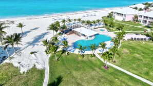 Un complexe hôtelier doté d’une piscine, d’une plage et offrant une vue sur l’océan.