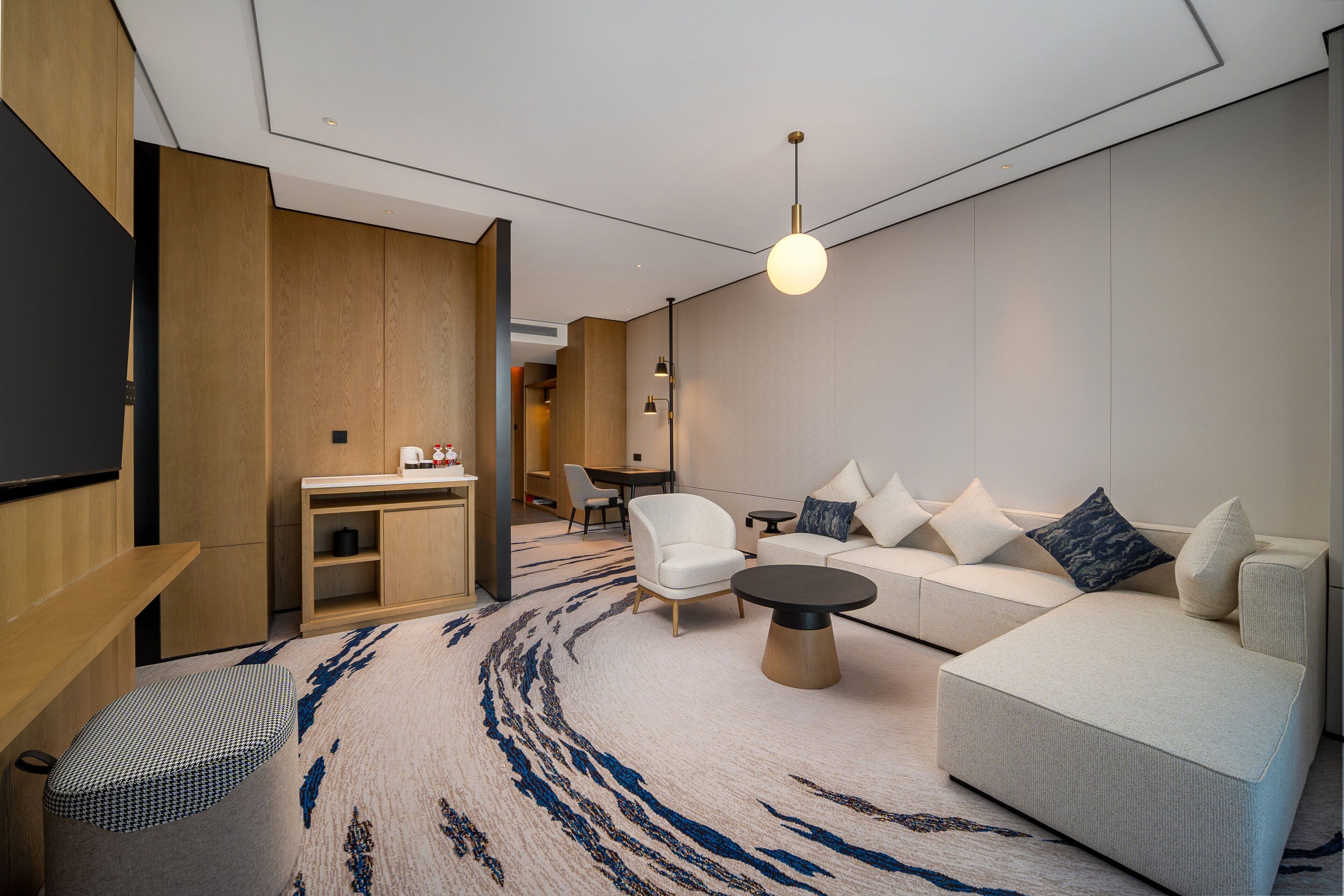 Una sala moderna con sofá, sillones, una mesa de centro y televisor.