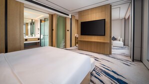 A modern hotel room with a large bed, a flat-screen TV mounted on the wall, and a walk-in closet. - Hilton Garden Inn Ordos Kangbashi (Ordos)