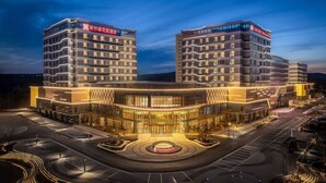 A modern hotel with a distinctive architectural design, featuring a central courtyard and multiple floors. - Hilton Garden Inn Ordos Kangbashi (Ordos)