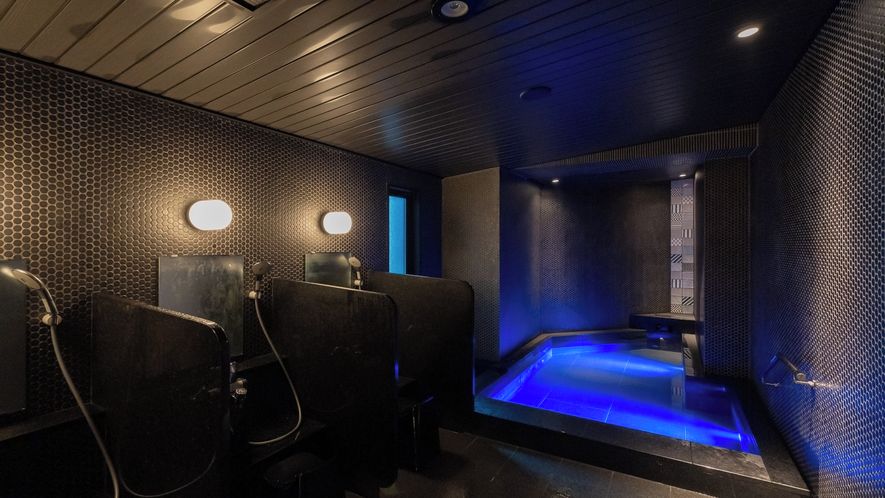 A spa area with a hot tub, seating, and wall-mounted lighting.