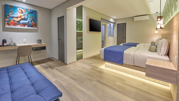 A modern hotel room with a bed, a desk, a chair, and a TV. - Hotel el Patio Cdmx (Mexico City)