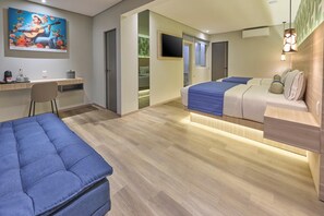 Une chambre d’hôtel moderne équipée d’un lit, d’un bureau, d’une chaise et d’un téléviseur.