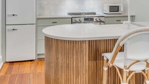 A modern kitchen with a central island, a microwave, and a stove. - The Saint's Suite - brand new 3 Bed/3 EnSuite Bath, 1 Block to King (Charleston)