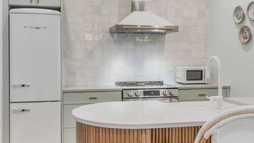 A modern kitchen with a central island, a microwave, and a stove.