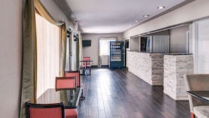A hotel lobby with a reception desk, seating area, and a vending machine. - Rodeway Inn Gainesville I-35 (Gainesville)
