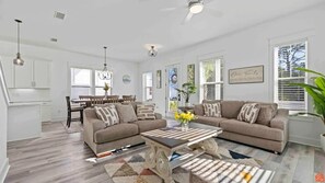Relax in this stylish living room with a beige sofa, coffee table, and dining area.