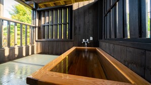 A wooden bathhouse with a large wooden bathtub, wooden walls, and a window. - Ureshino Onsen Kujaku (Ureshino)