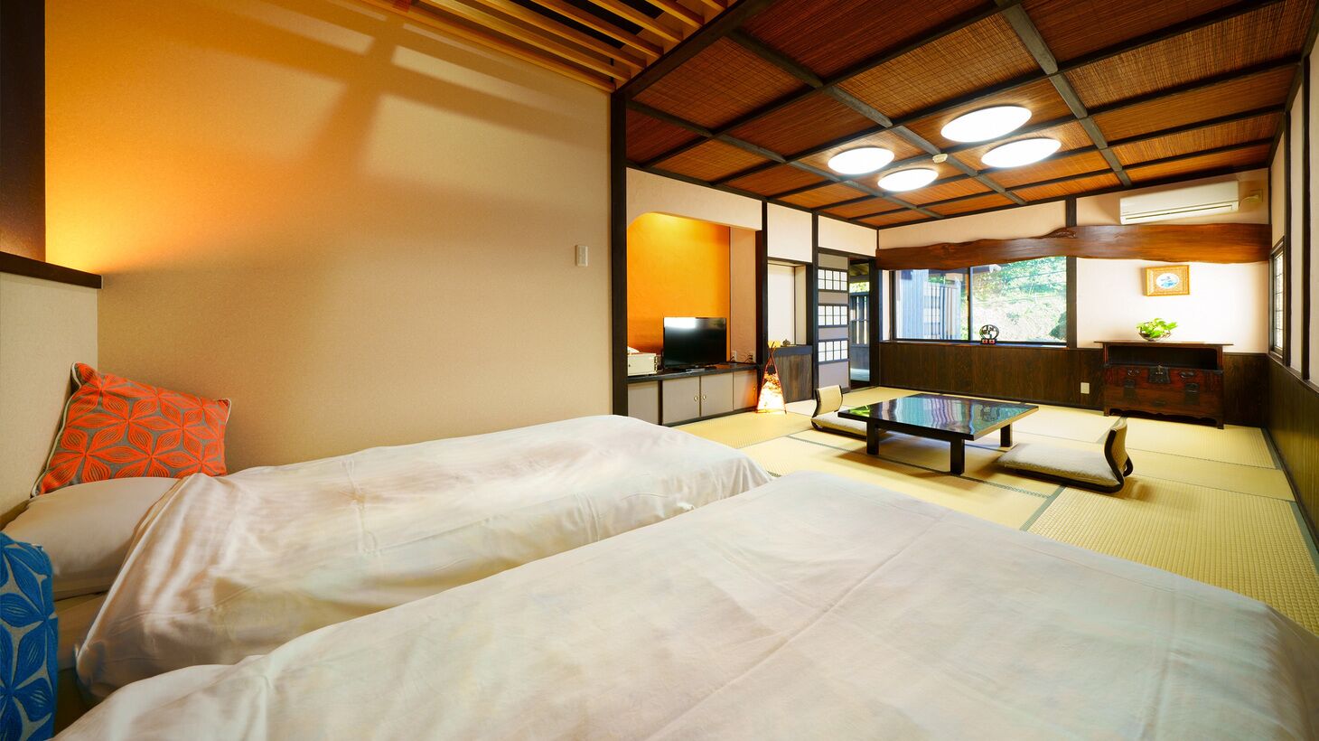 Habitació japonesa tradicional amb tatami, una taula baixa i una televisió.