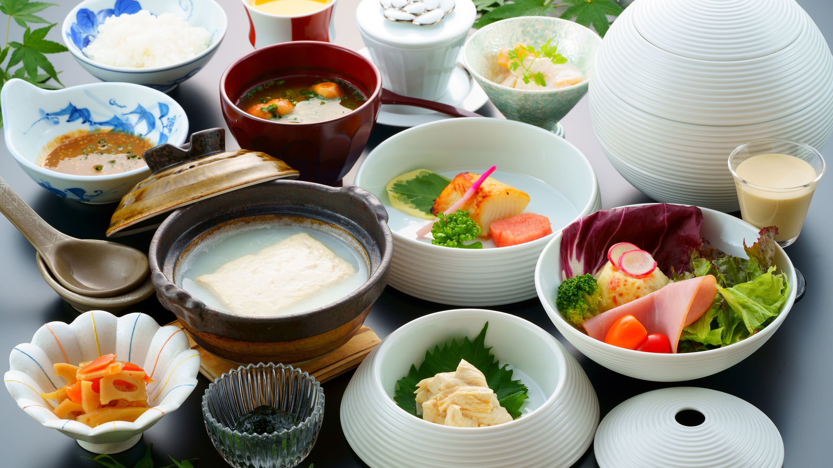 A variety of Japanese dishes including sushi, bowls of soup, and a hot pot.