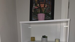 A white cabinet with two doors, a shelf above, and a trash bin to the left. - Tranquil corporate Rental in lovely Minneapolis with WiFi (Minneapolis)