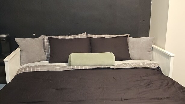 A bed with a dark brown bedspread, white headboard, and multiple pillows. There is a framed picture on the wall above the bed. - Tranquil corporate Rental in lovely Minneapolis with WiFi (Minneapolis)