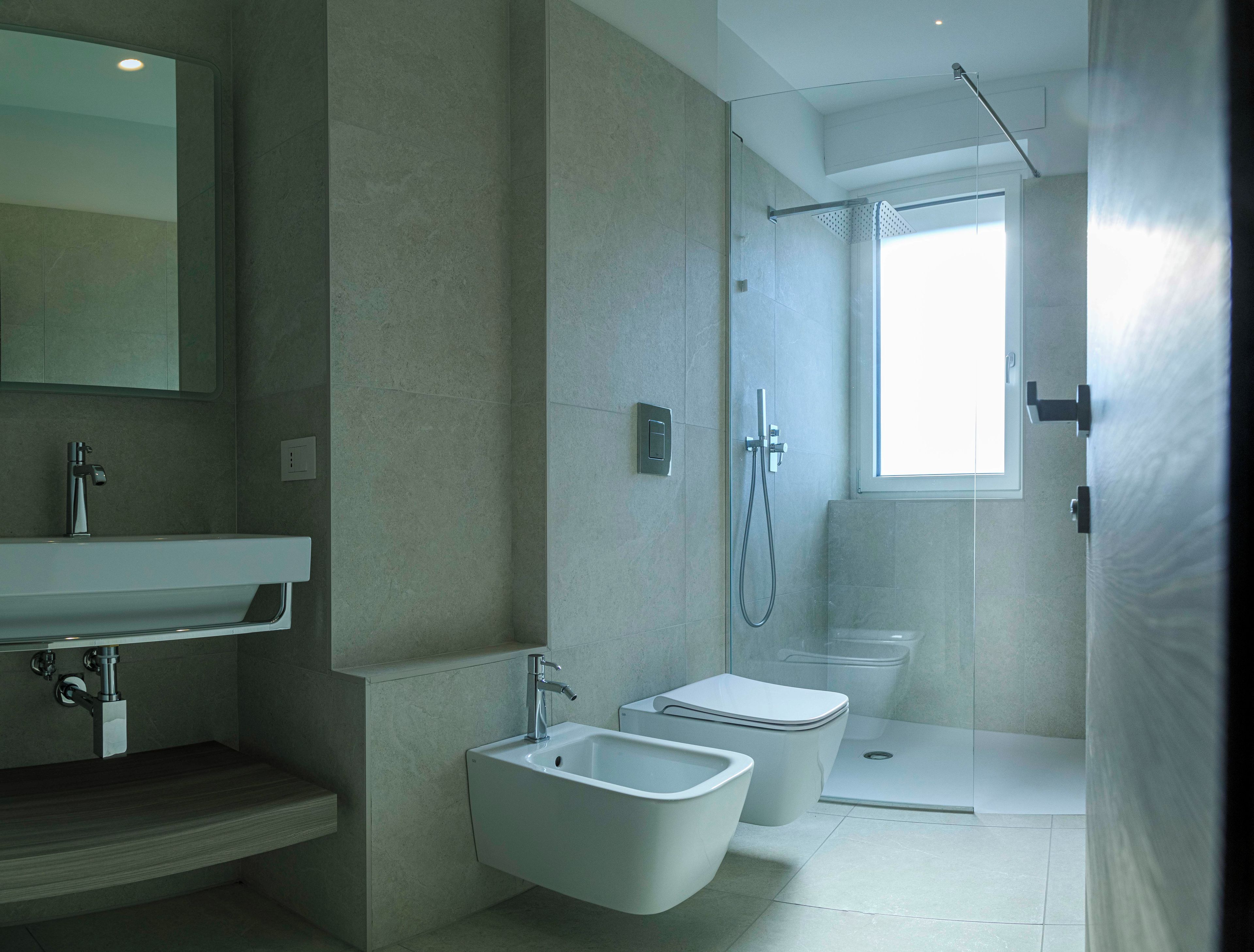 Un baño moderno con ducha, inodoro, bidé y lavamanos.