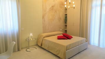 A modern bedroom with a bed, a small table, and a chair.