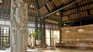 A spacious lobby with a high ceiling, a central column with intricate carvings, seating areas, and a reception desk. - 2BD Grand Bliss Vidanta Resort RM (Playa del Carmen)