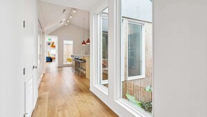 Una cocina moderna con comedor, piso de madera y ventanas amplias.