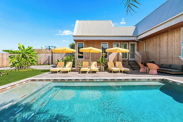 The pool and the loungers in front of the villa.