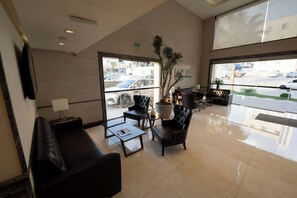 A spacious lobby with a large seating area, a coffee table, and a potted plant. - Gloria Boutique Hotel (Amman)