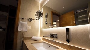 Un baño moderno con un espejo grande, un lavabo y un perchero para toallas.