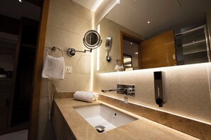 A modern bathroom with a large mirror, a sink, and a towel rack. - Gloria Boutique Hotel (Amman)