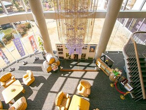 Eine Hotelhalle mit einer Chandelüster, einer Sitzecke und einer Treppe.