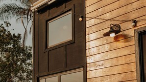 A wooden cabin with a large window and a door. - Dila's Lodge (Sao Roque)