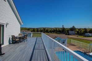 Une terrasse dotée de mobilier d’extérieur, d’une piscine et offrant une vue sur le paysage environnant.