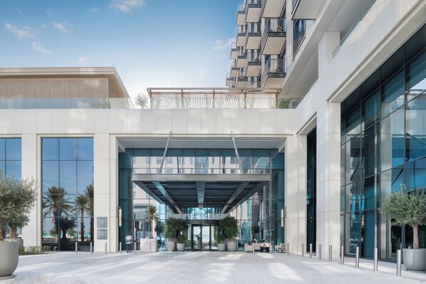A modern building with large glass windows, a covered entrance, and potted plants. - Vida Beach Resort Marassi Al Bahrain (Manama)