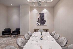 A conference room with a long table, grey chairs, and a framed artwork on the wall. - Vida Beach Resort Marassi Al Bahrain (Manama)