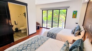 A modern hotel room with two beds, a large window with a view of greenery, a painting on the wall, and a ceiling light. - Burbi Lake Lodge (Cabeceras)