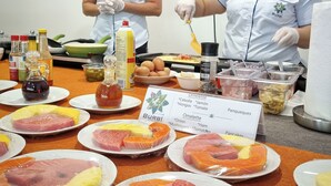 A buffet setup with various food items and two staff members serving. - Burbi Lake Lodge (Cabeceras)