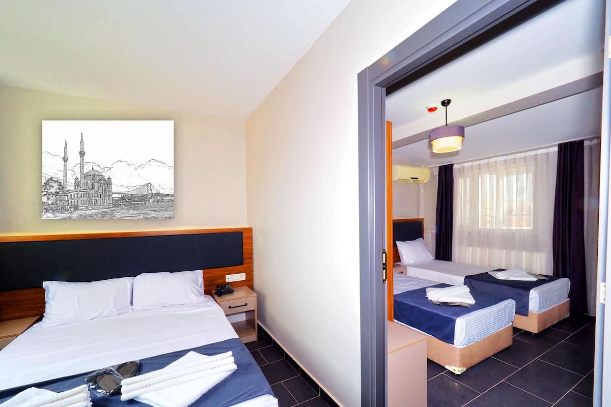 Ett hotellrum med två sängar, en stor spegel, ett konstverk som föreställer en stadsbild och en modern design.