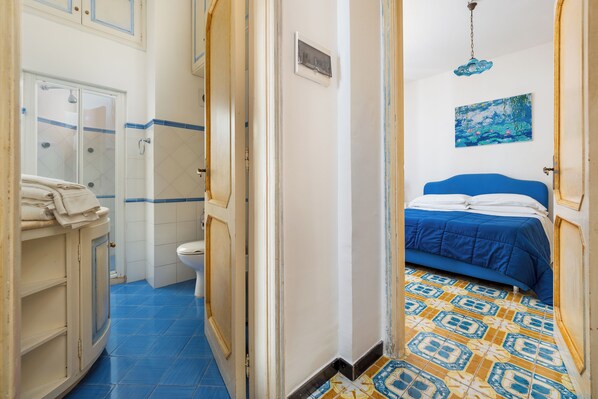 A bathroom with a shower, toilet, and a sink with a towel. - Casa Simona (Positano)