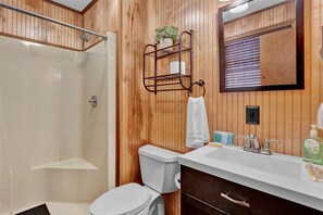 Een douche, handdoeken, zeep, toiletpapier