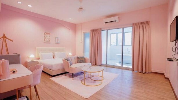 Una camera d'albergo moderna con un letto, una scrivania, una sedia e un'ampia finestra con tende.