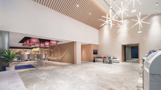 A spacious lobby with a high ceiling, modern lighting fixtures, and a seating area with a sofa and chairs. - Holiday Inn Express Puer Simao by IHG (Pu'er)