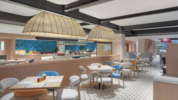 Un restaurant moderne doté d’un bar, d’un espace pour s’asseoir et d’une cuisine située à l’arrière.