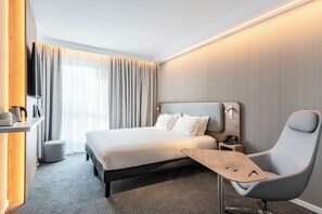 A modern hotel room with a large bed, a desk with a chair, a small table, and a telephone. - Holiday Inn Express and Suites Reims Rives De Vesle by IHG (Reims)