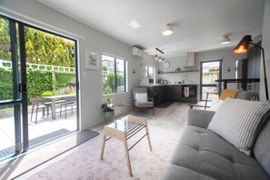 Un espacio habitable moderno con un sofá, una mesa de comedor y una zona de cocina.