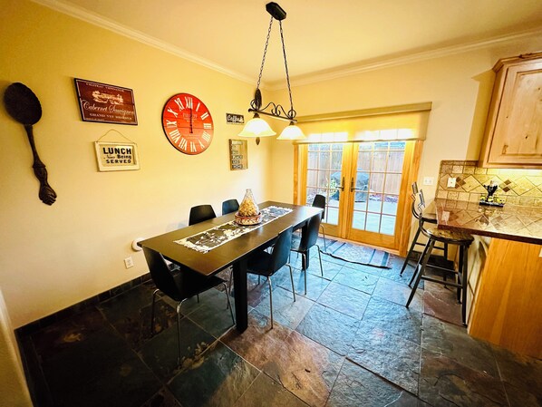 A dining area with a long table, chairs, and a clock on the wall. - Charming & Central 2200 sq. feet house in Davis walking distance to everywhere (Davis)