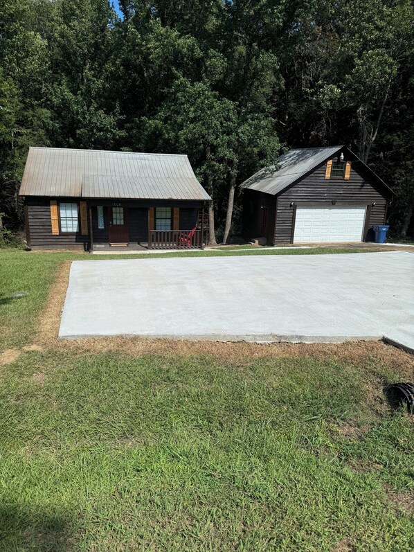 Un immeuble de deux étages doté d’un garage, d’un porche et d’une grande allée.