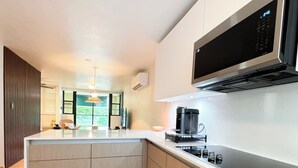 Uma cozinha moderna com uma ilha central, micro-ondas embutido e máquina de café.