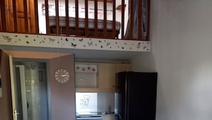 A compact living space with a dining area, kitchenette, and a bed. - Maisonnette with swimming pool, tennis court and boules pitch 5 mins from Etang de Thau   (Loupian)