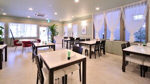 A hotel dining area with tables, chairs, and potted plants. - Hotel Hayashiya Ishinomaki (Isinomaki)